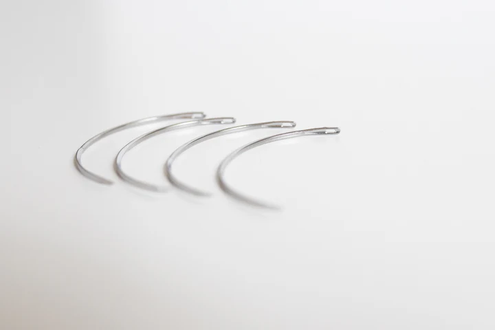 Three silver hoop earrings on a light gray background