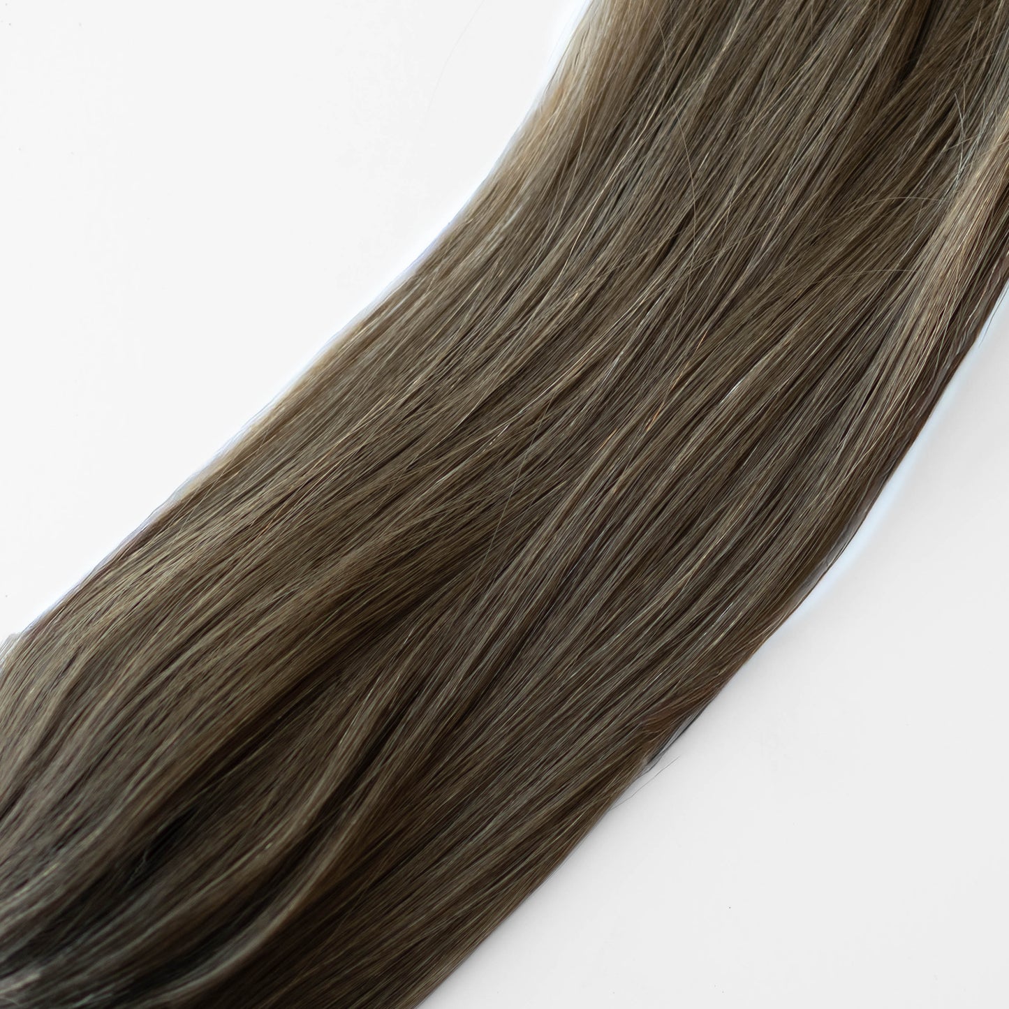 Close-up of brown hair extensions on a white background