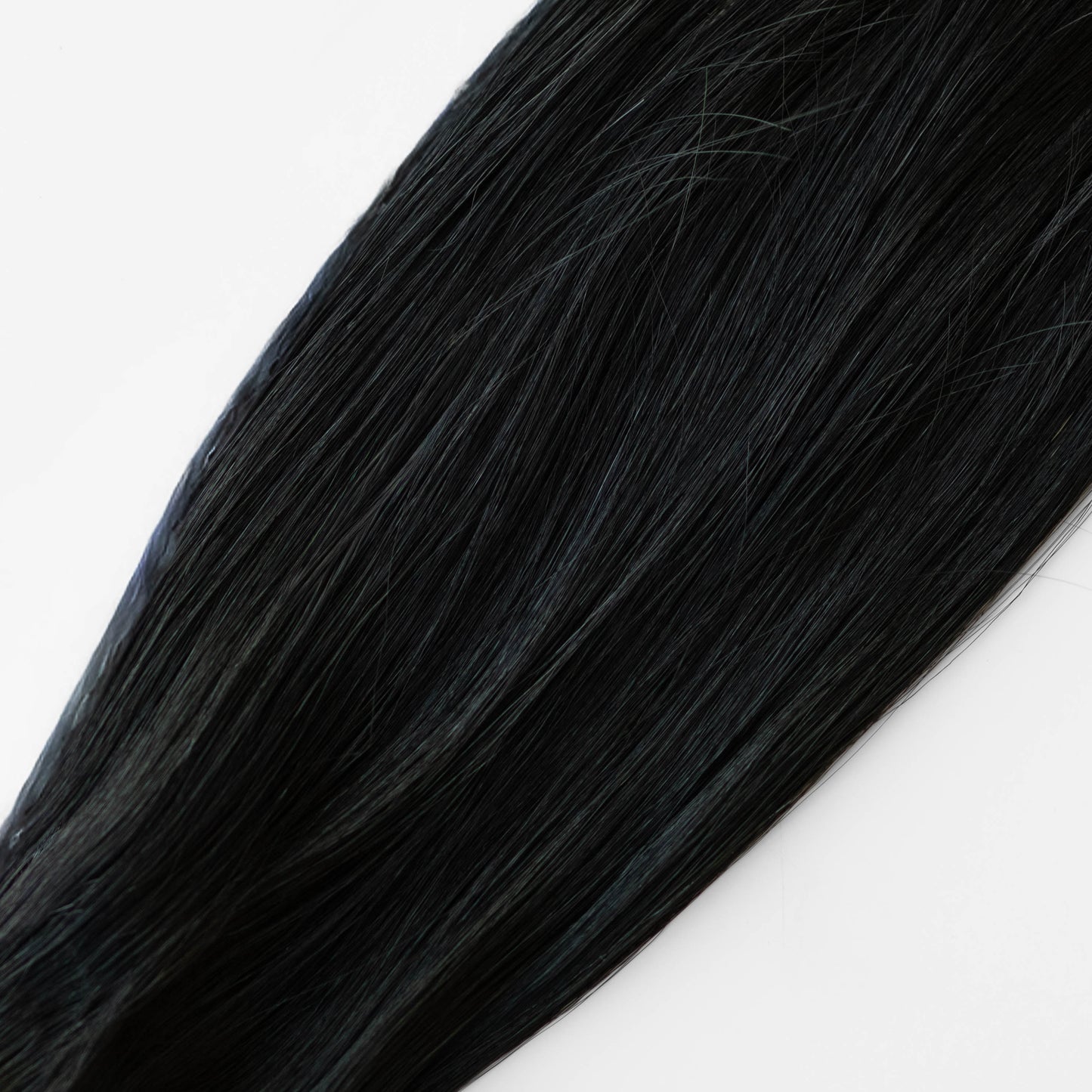 Close-up of black hair extensions on a white background