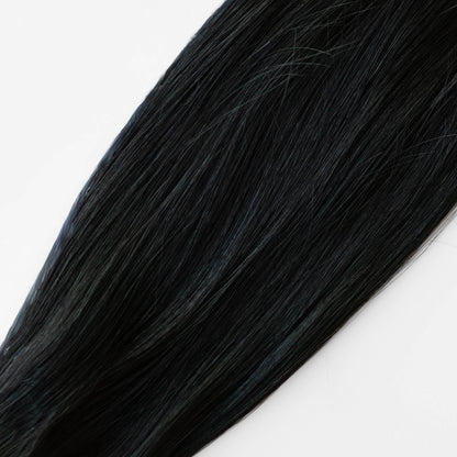 Close-up of black hair extensions on a white background