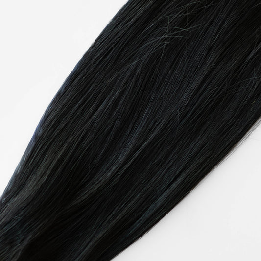 Close-up of black hair extensions on a white background