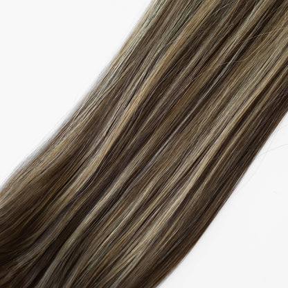 Close-up of brown and blonde hair extensions on a white background