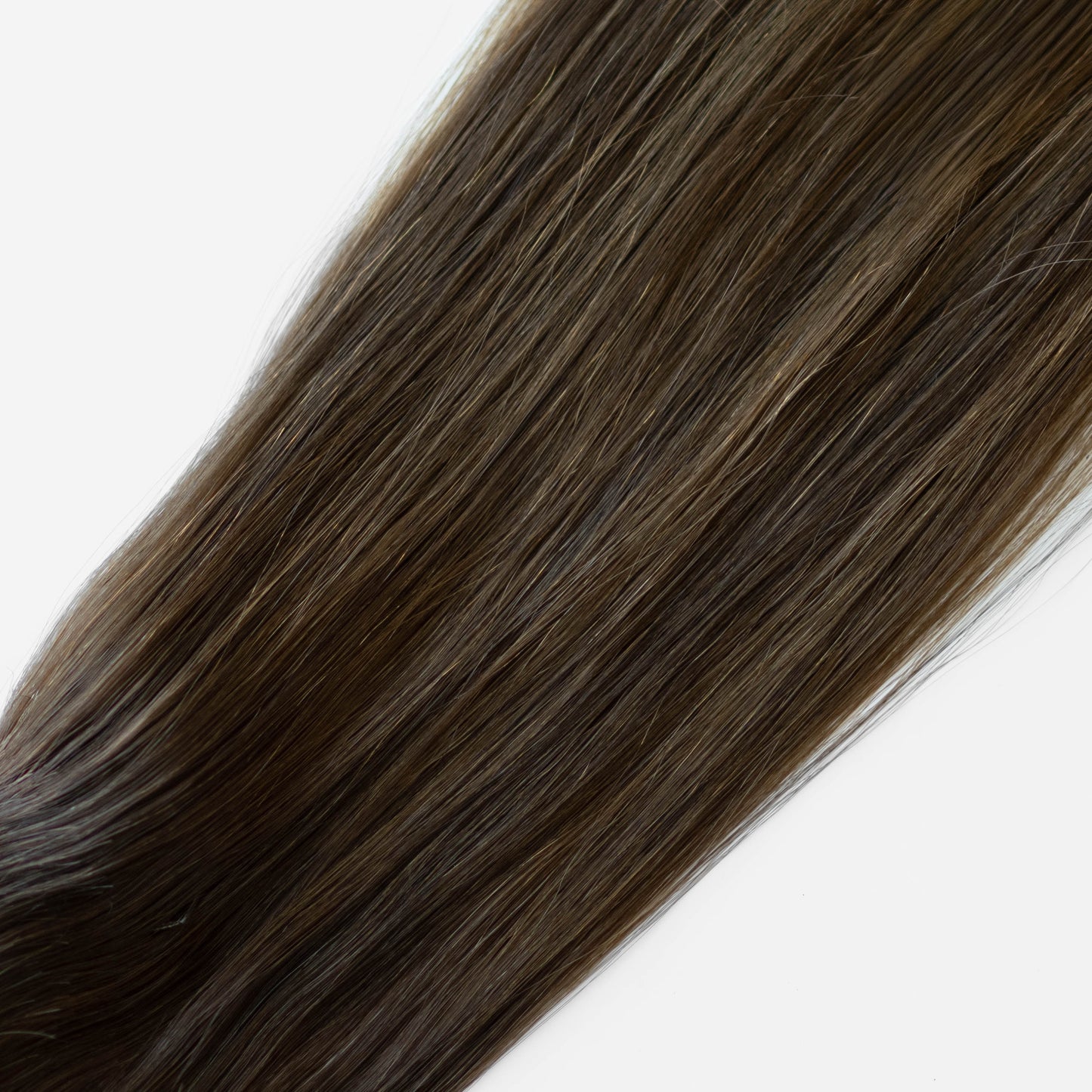 Close-up of dark brown hair extensions on a white background