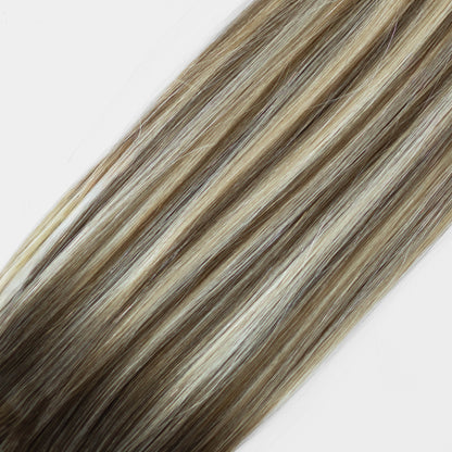 Hair extensions with brown and blonde color on a white background