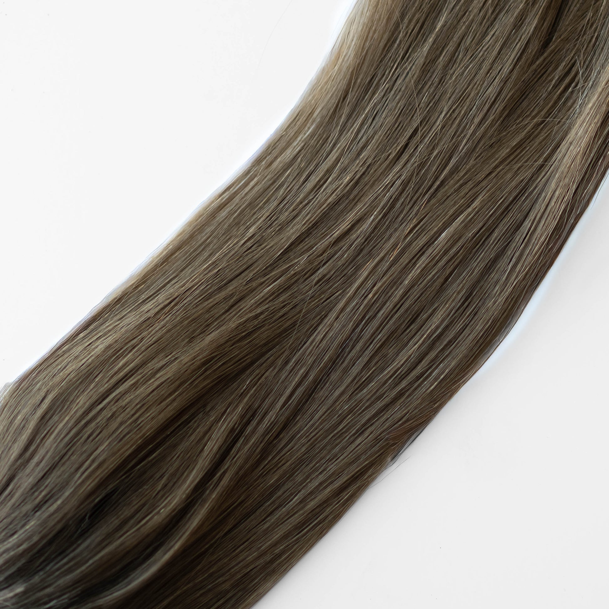 Close-up of brown hair extensions on a white background