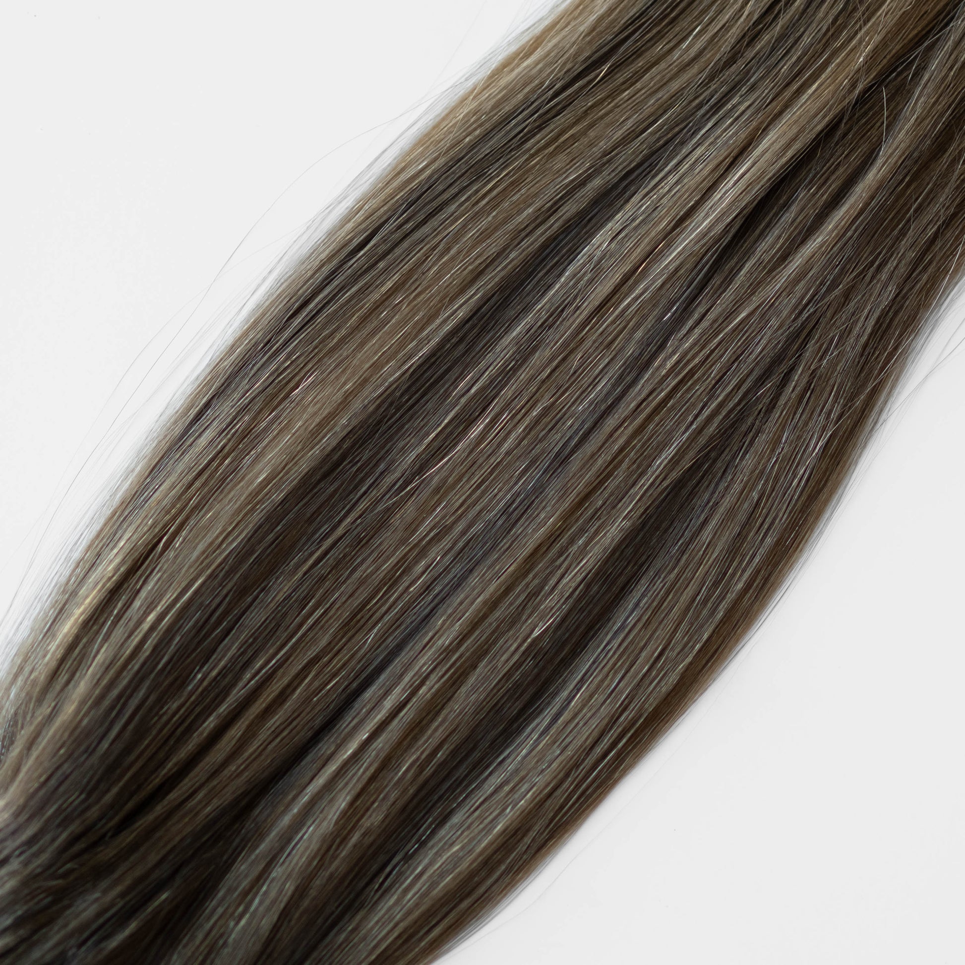 Close-up of brown hair extensions on a white background