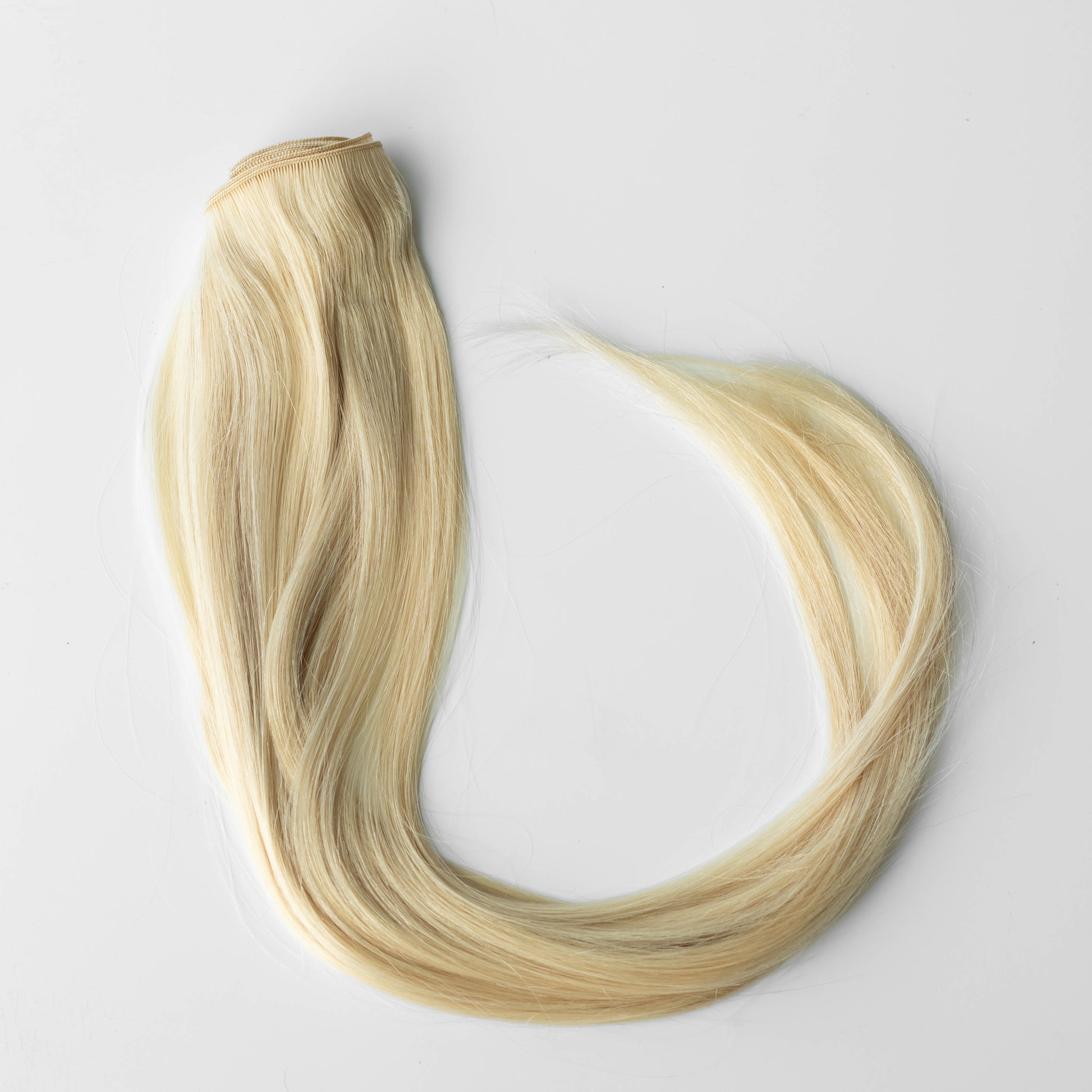 Blonde hair extensions on a white background