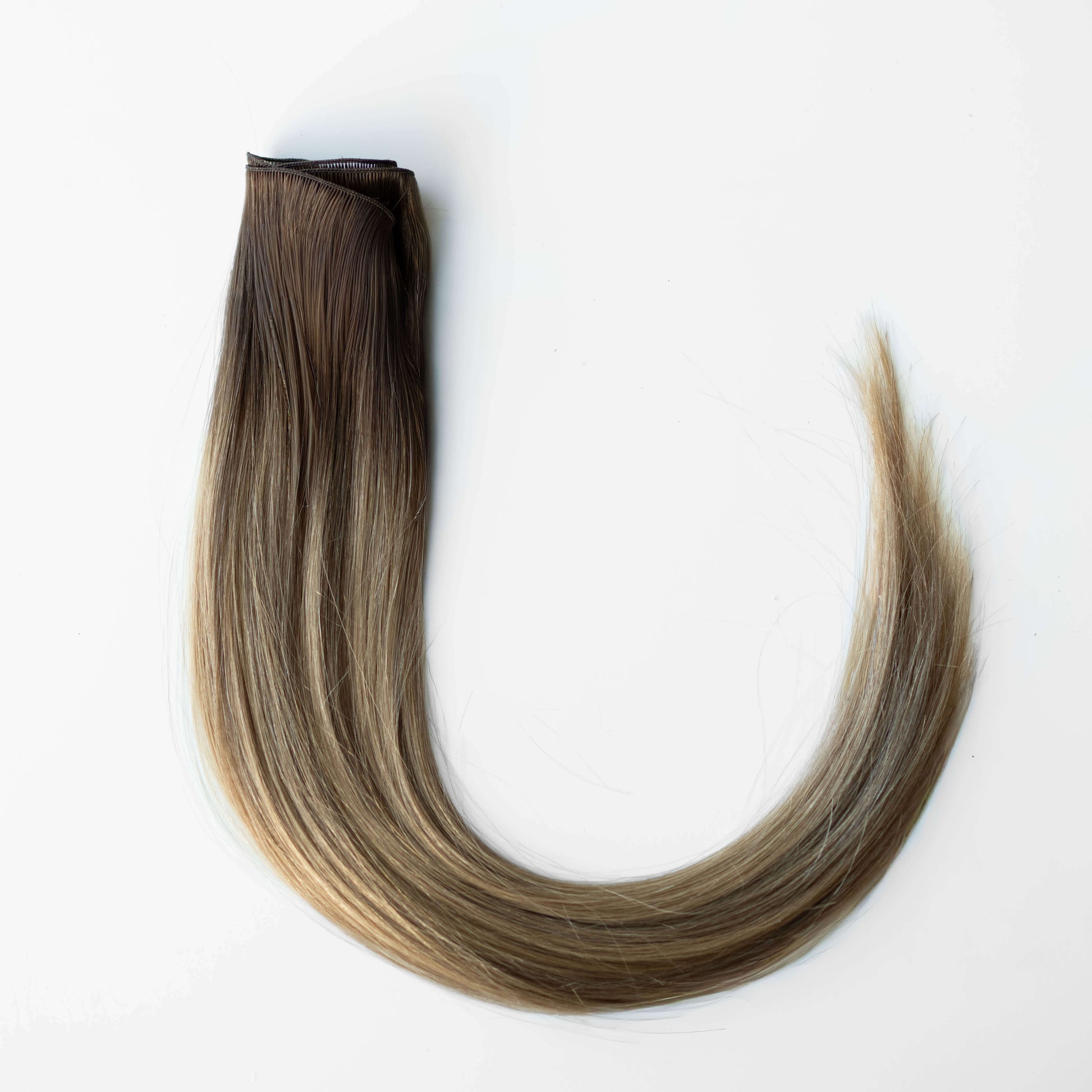 Brown and blonde hair extensions on a white background